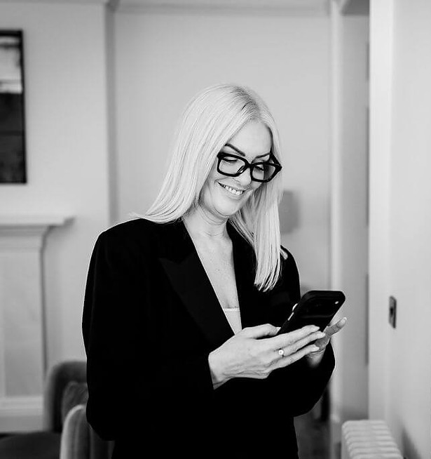 Woman with sleek blonde hair looking at her phone