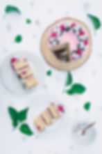 Top 10 cakes. Top 10 cake recipes. Beautiful food photography of an Almond, Lemon & Raspberry Cake with a White Chocolate Drizzle. Flat lay with sliced cake, flowers, leaves and berries.