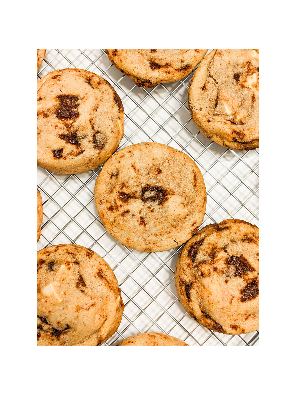 Soft, gooey Cinnamon Bun Cookies on a cooling rack with golden edges and caramelized cinnamon sugar pieces.