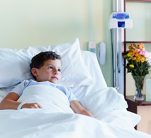 Niño en cama de hospital