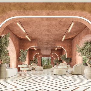 Contemporary Mediterranean interior restaurant with terracotta walls, arched openings, bold black-and-white geometric tile flooring, green velvet seating, and potted plants for contrast.