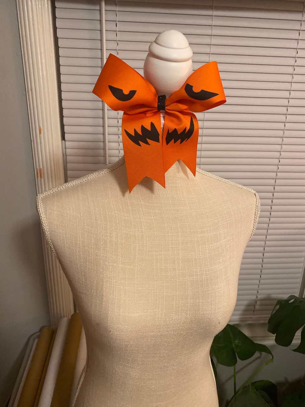 Orange cheer bow with jack-o-lantern face
