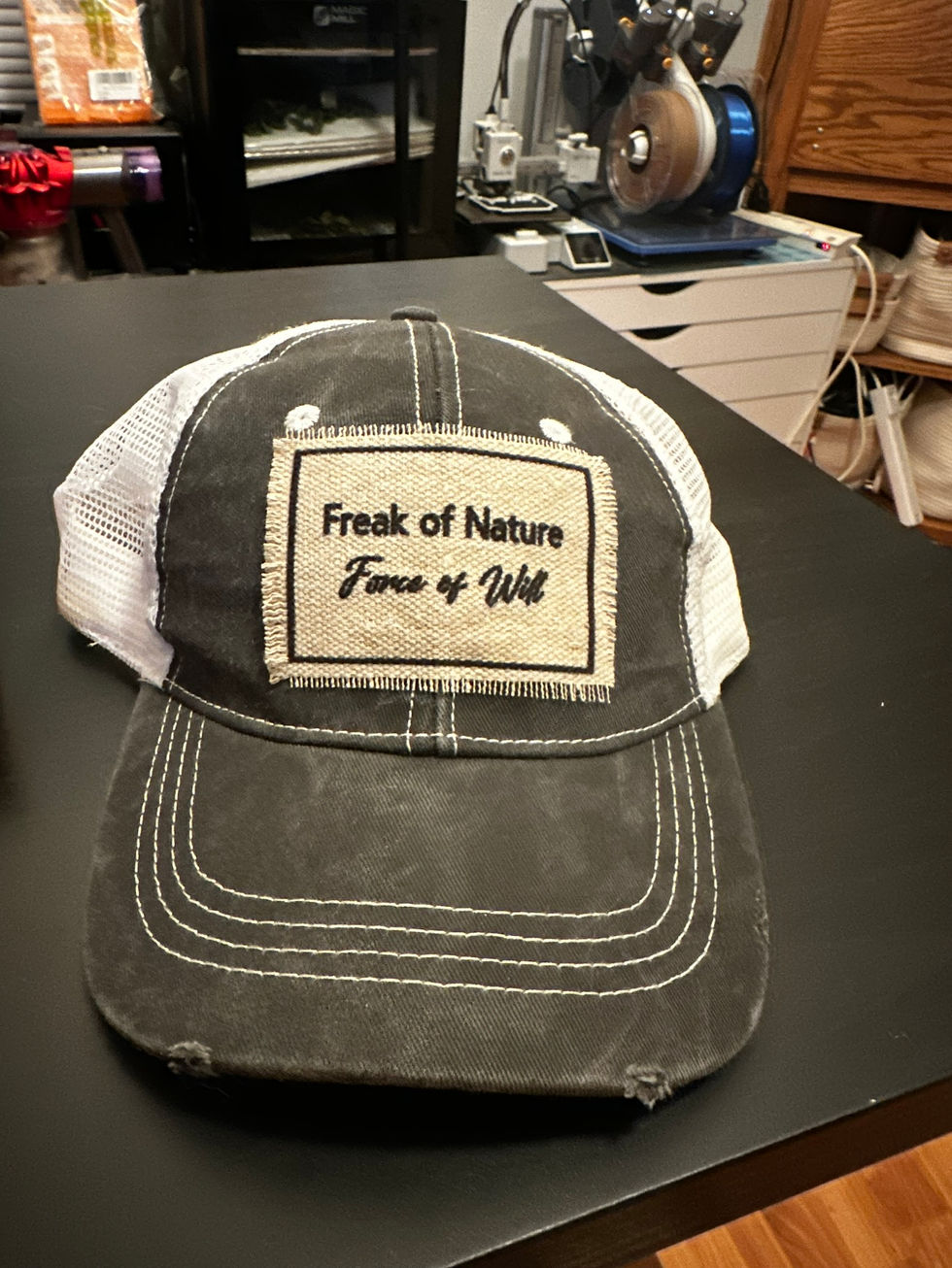 Baseball cap with a sublimated patch that says "Freak of Nature. Force of will"