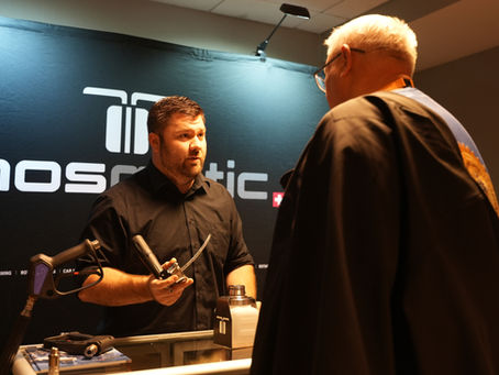 Mosmatic Representative demonstrating and showcasing equipment to an man on the showroom floor at the Wash and Learn Midwest.