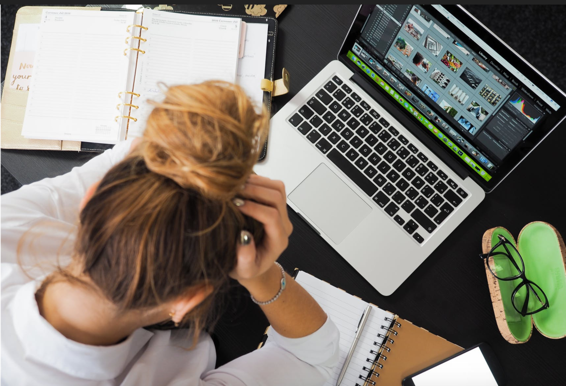 Woman at her desk with head in her hands