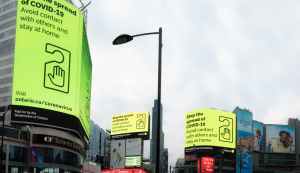Picture of Dundas Square with large billboards warning of COVID-19