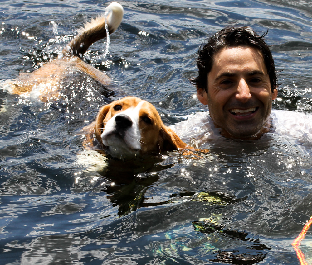 Charles Gluckstein swims in a lake with his dog Duke