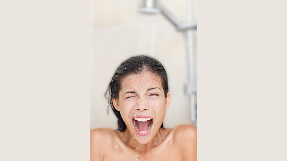 A woman reacts with surprise and exhilaration as she showers under freezing cold water.