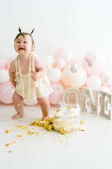 standing baby laughing at mess during smash and splash session