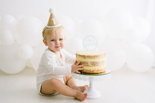Smiling baby in party hat during first smash and splash session