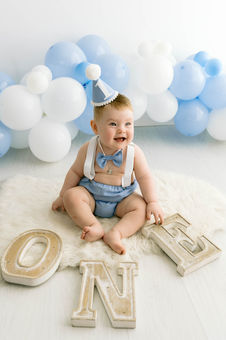 chubby baby wearing party hat during smash and splash session