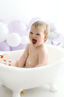 baby laughing and splashing in mini bath tub during smash and splash session