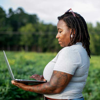 Farmer taking inventory of crops while outside standing in the field