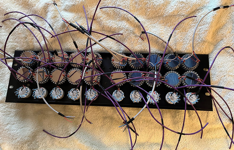 A circuit board with multiple round components and purple wires on a beige textured background. The setup appears intricate and technical.