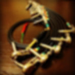 Several short right-angled patch cables for guitar pedals, and one red chili pepper, opposite angle