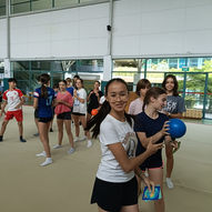 Smiling teenagers enjoying fun group ball game activity during Teen Yoga class — East West Yoga Singapore school ages 13 to 18