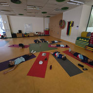 Children lying in savasana relaxation pose on yoga mats in school — East West Yoga Kids Yoga Singapore
