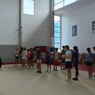 Yoga instructor introducing group ball game activity to teenagers in spacious school gym — East West Yoga Teen Yoga Singapore ages 13 to 18