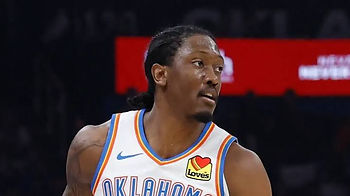 Basketball player in white Oklahoma jersey with Love’s patch looks off to the side on the court.