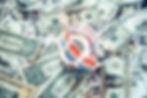 Roll of Voted Today stickers resting on scattered U.S. dollar bills, suggesting money and election spending.