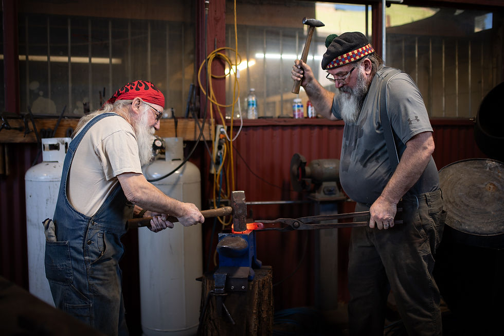 Blacksmith Instructors and Knife Makers Jeremy Lewis (left) and Jim Lovelace (right) work together to forge a knife at the DIYcave