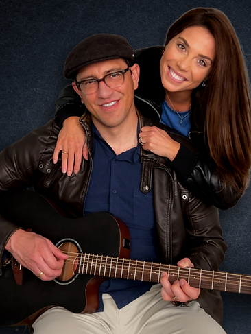 Husband and wife music duo Emma and James posing with guitar and microphone in a studio setting