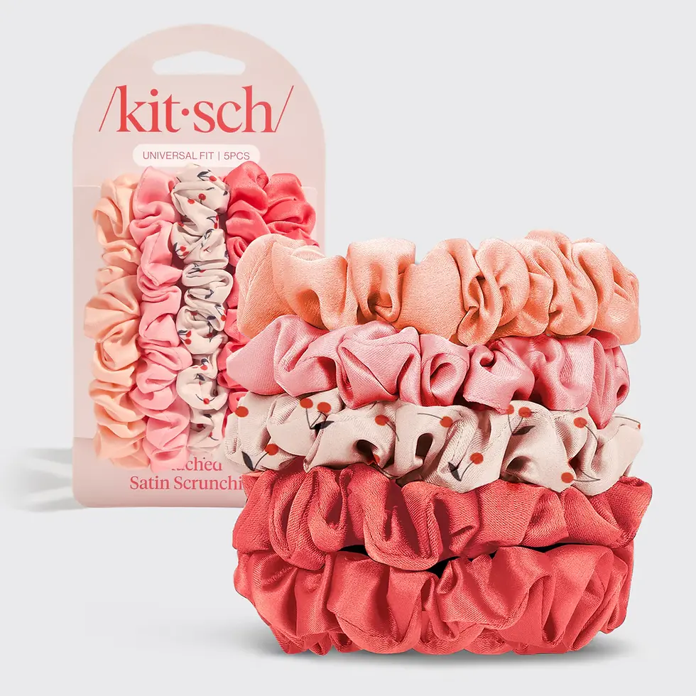 Stack of Kitsch ruched satin scrunchies in Cherry Blossom tones beside product packaging