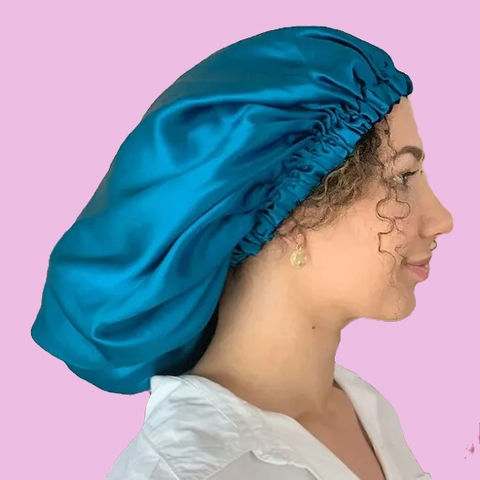 Curly Hair Products for sleeping. Image shows a a woman with curly hair wearing a Bliss Silk Bonnet