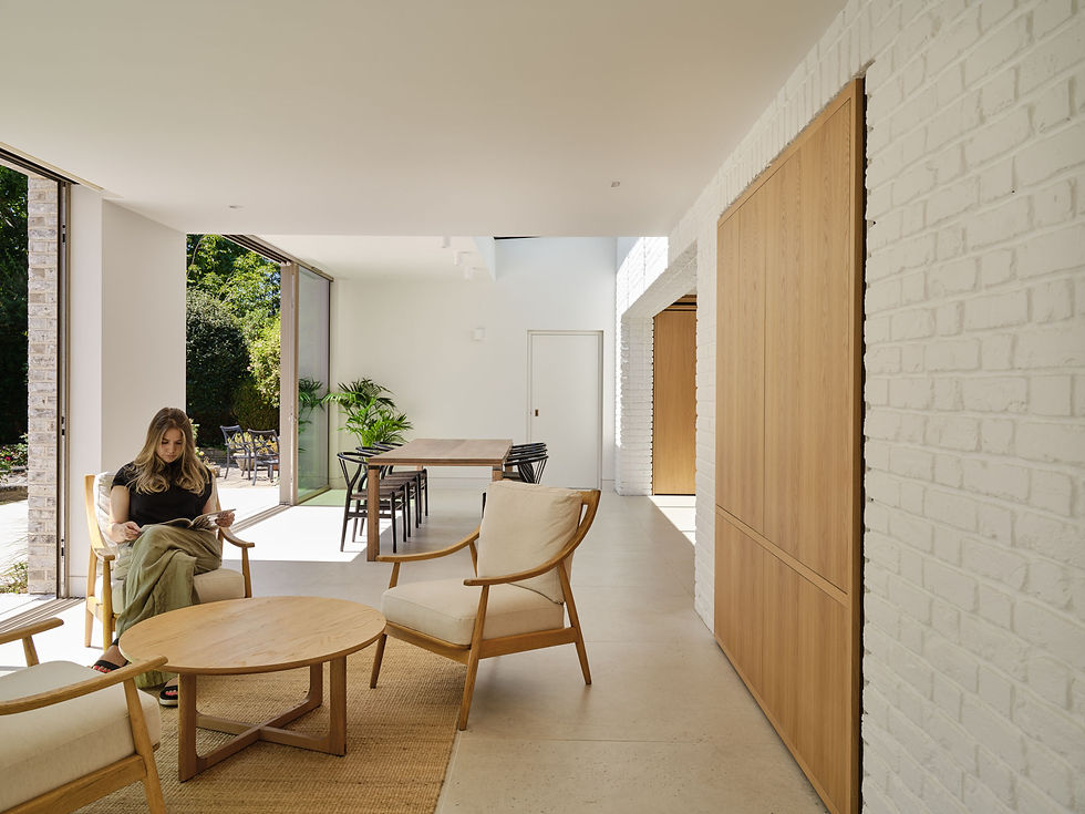 Seating area beside the glazing, with the painted brick wall running the length of the room