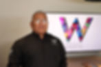 Man wearing black shirt stands in front of a W GROUP WORLDWIDE logo.