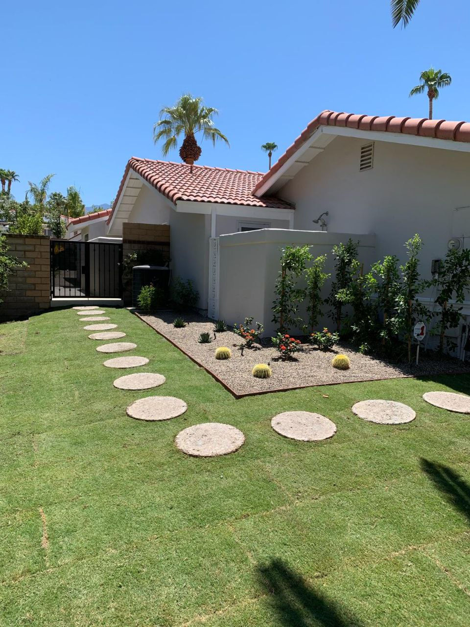modern backyard landscaping with stepping stone path and artificial turf