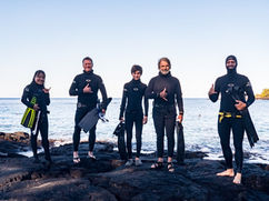 a group of freedivers gathers on the rocks