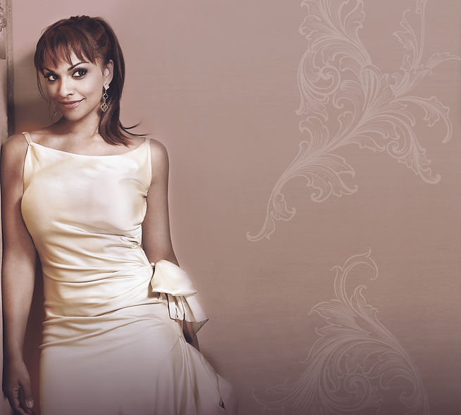 Danielle de Niese in a cream gown on a floral background
