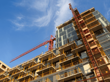 A mid-rise apartment building under construction in Kenya, showing scaffolding and workers on-site — potential candidate for Change of Use to commercial or mixed-use.