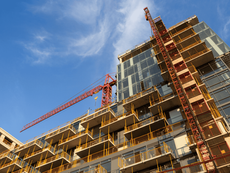 A mid-rise apartment building under construction in Kenya, showing scaffolding and workers on-site — potential candidate for Change of Use to commercial or mixed-use.