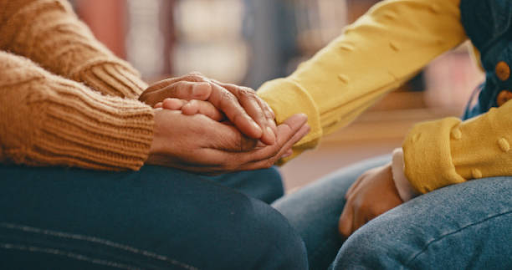 A man holding his partners hand.
