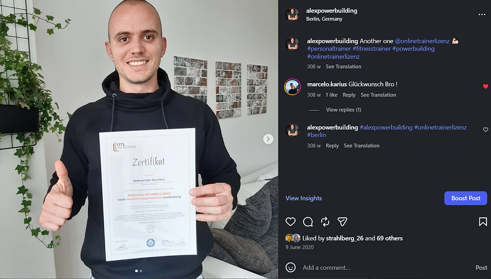 Alex Powerbuilding smiling, holding a certificate with "Zertifikat" visible. Background shows houseplants and geometric wall art. Cozy indoor setting.
