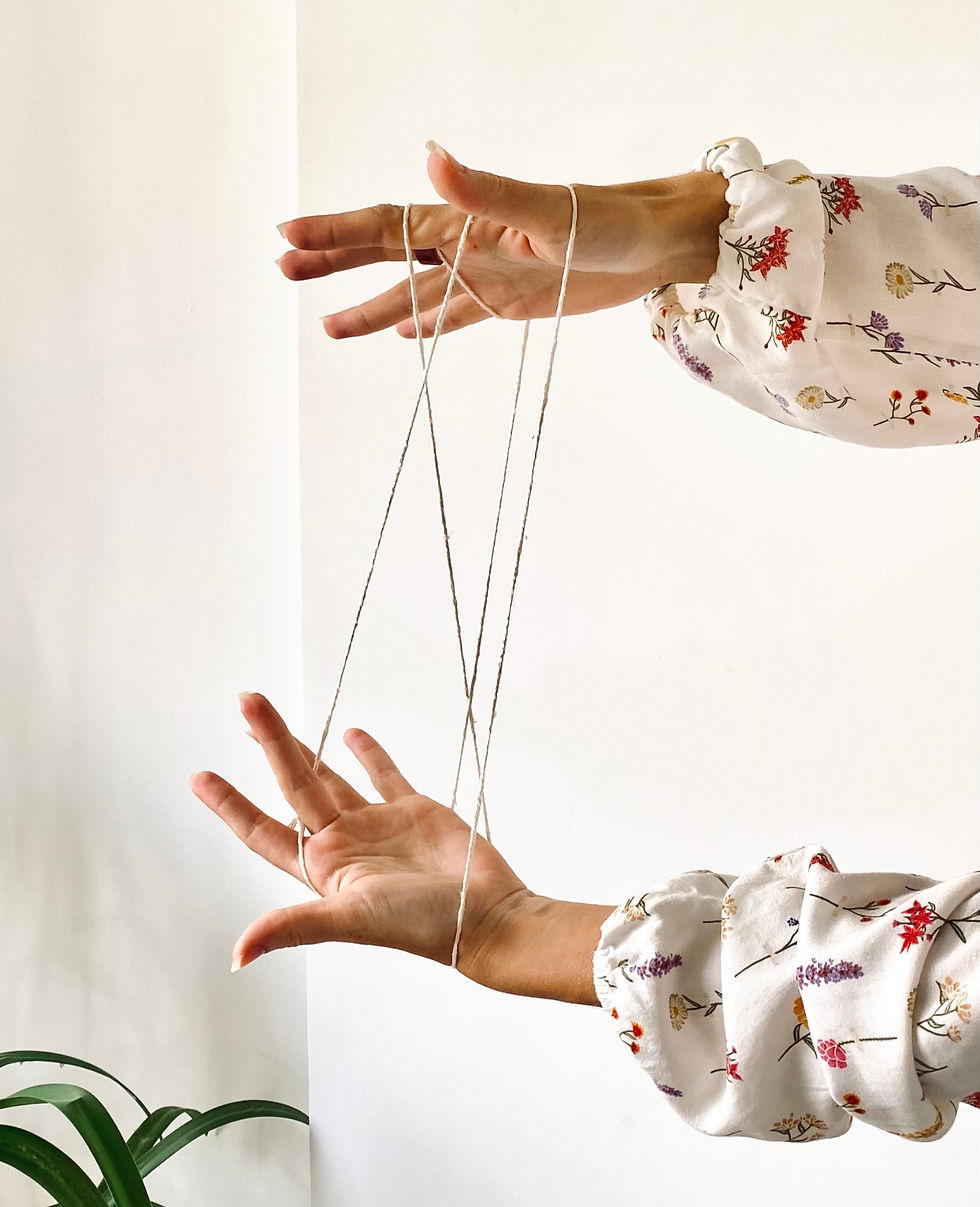 Mãos emaranhadas por um barbante, simbolizando a sensação causada pela ansiedade