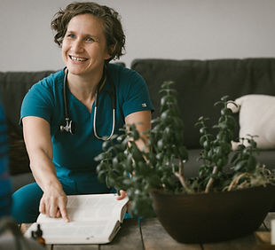 Dr. Crystalin Montgomery pointing to the inside of a book, smiling at a person sitting across from her. 