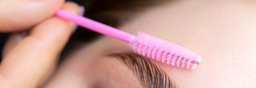 Augenbrauen werden mit pinker Bürste sanft in Form gebracht beim Brow Lifting