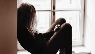 Tristeza en una mujer en una ventana