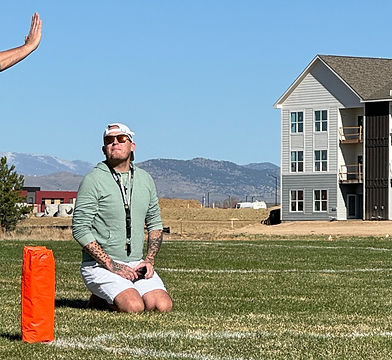 Kyle from Schwartz Athlete Spotlight kneeling on a football field during athlete film evaluation coverage