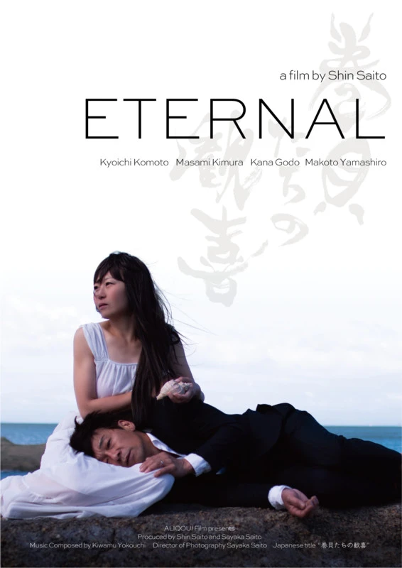 A couple on a beach with the man's head in the woman's lap, who is looking away. He wears a black suit and she wears a white dress. Eternal.