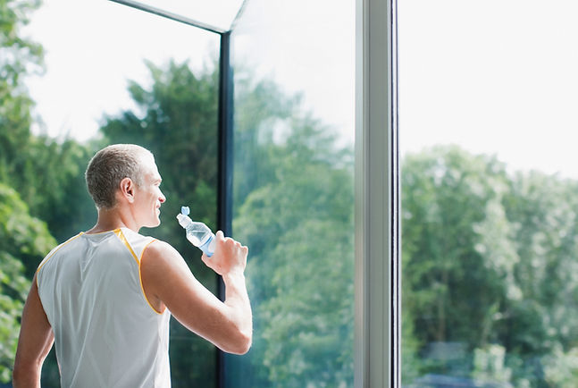 Mann trinkt Wasser aus einer Flasche