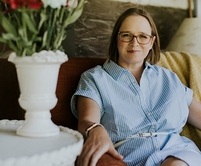 Professional portrait of Theresa Smith sitting down, smiling and looking relaxed in business attire.
