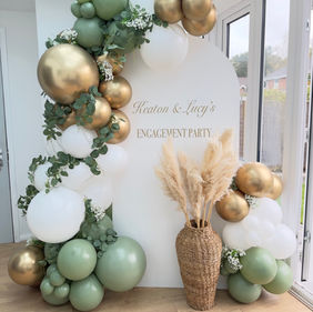A beautiful arch backdrop with balloon garland in eucalyptus green, white and gold colours!