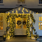 Exterior Christmas lights for house, with fron door decorationg with christmas garlands
