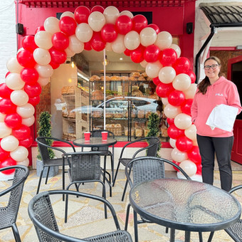 Classic balloon arch in red and cream colours, installed for local bakery