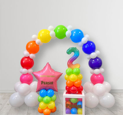 Small balloon setup for baby birthday party on a bright rainbow colours with personalisation
