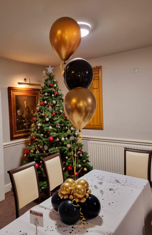 Christmas table balloon centerpieces in black and gold colours, delivered by Confetti Party, balloon decorators company in Guildford